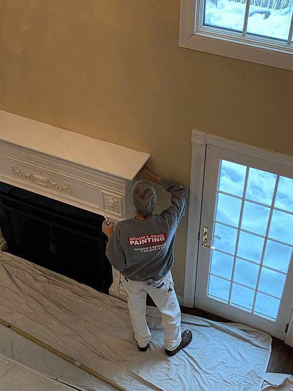 man fixing fireplace mantle suite interior painting 8
